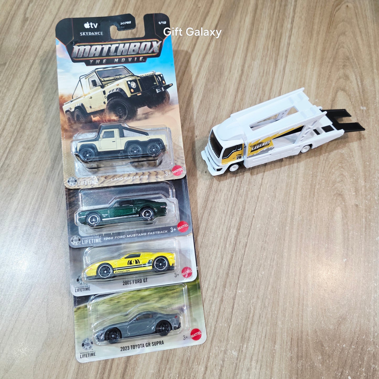 Matchbox Land Rover 6x6, 1968 Ford Mustang Fastback, 2005 Ford GT, 2023 Toyota GR Supra & Lose Hot Wheels Kousoku Hauler Transport Truck